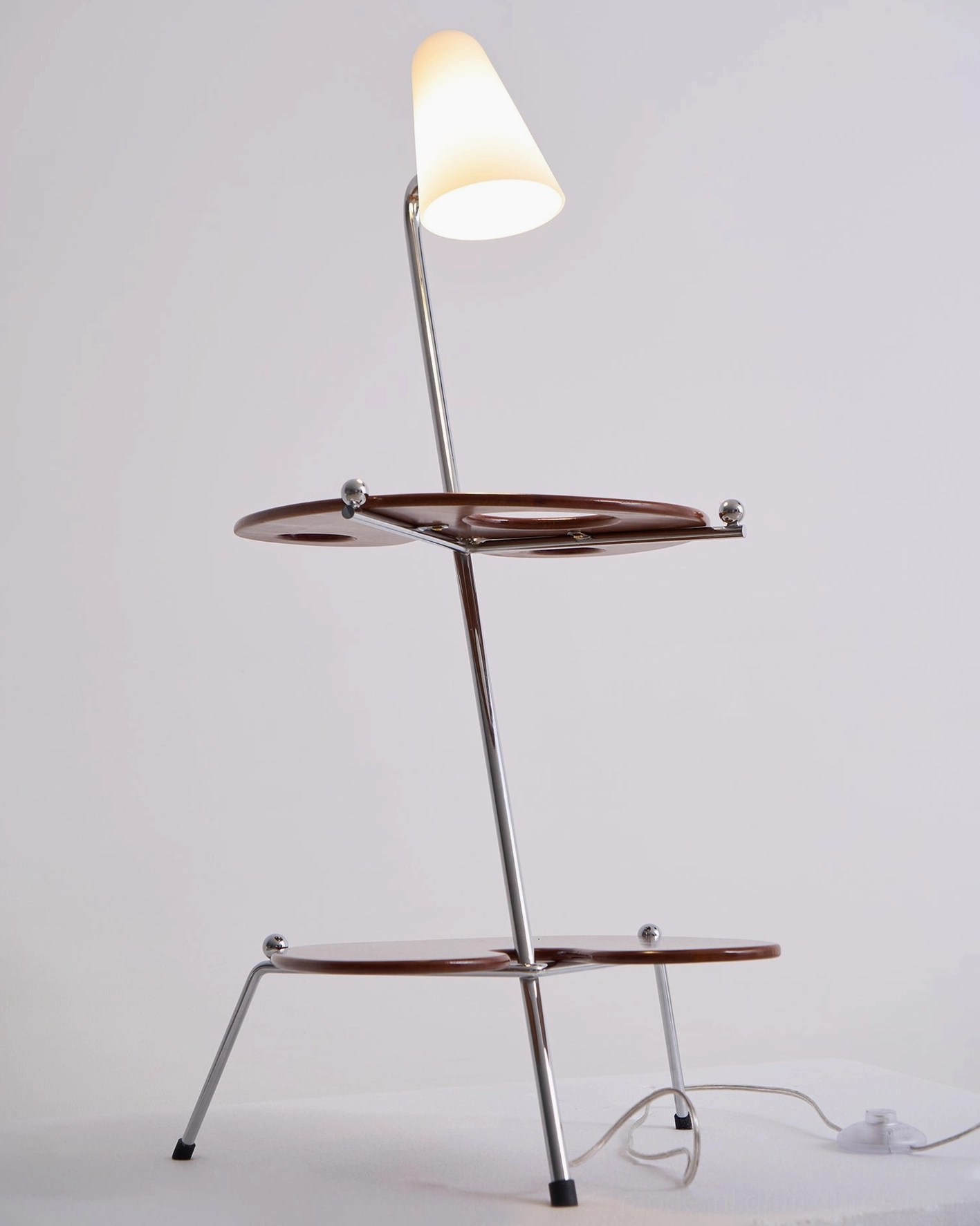 Sculptural floor lamp and side table combination providing ambient lighting and functional storage in modern home