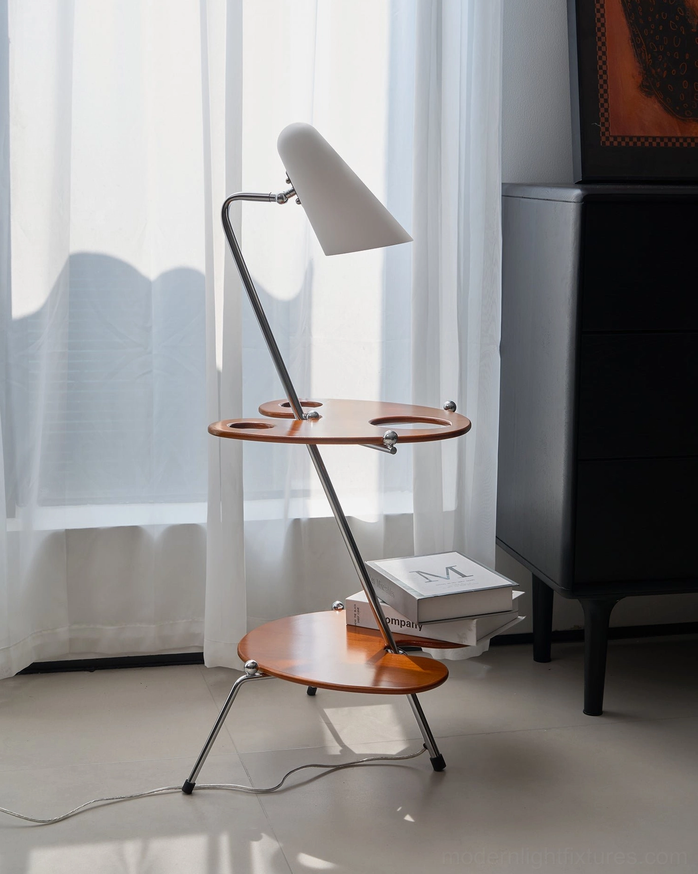 Modern architectural floor lamp with white shade beside dark storage cabinet, side profile in natural lighting
