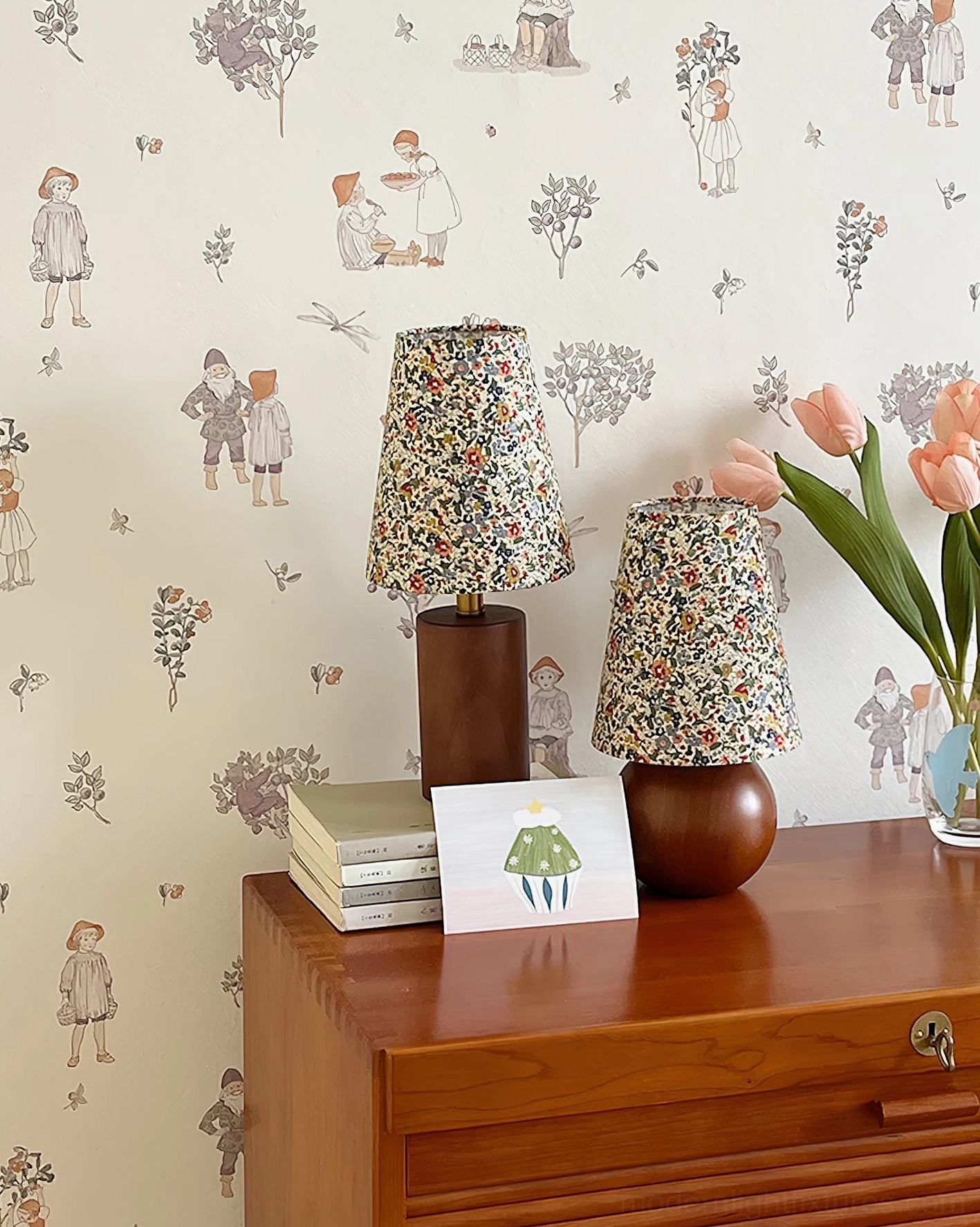 Floral table lamps on wooden side table in vintage cottage entryway with botanical wallpaper