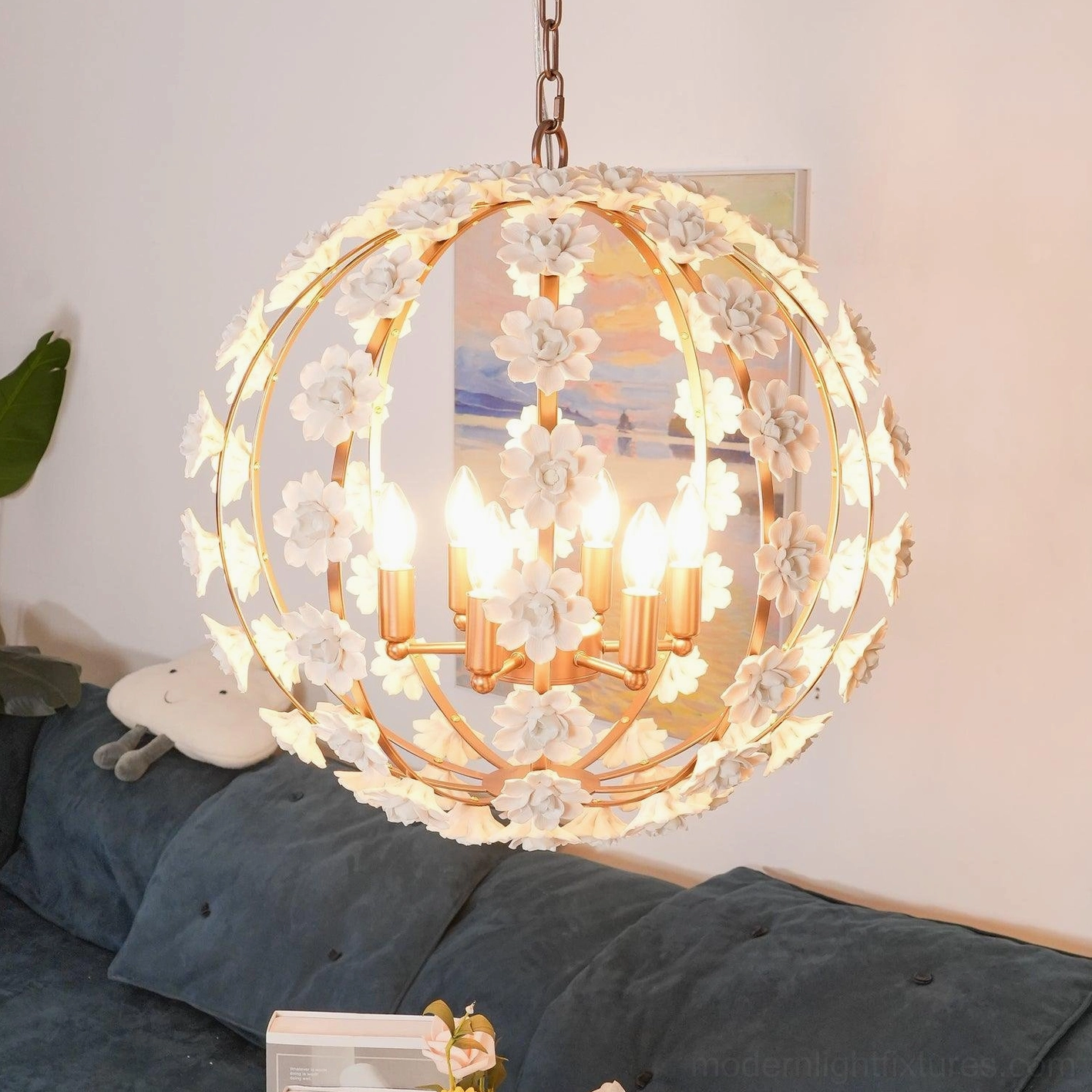 Brightly lit spherical floral pendant light with candle bulbs in cozy living room setting
