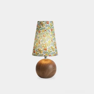 Handcrafted floral table lamp with spherical wooden base and vibrant botanical fabric shade, frontal view