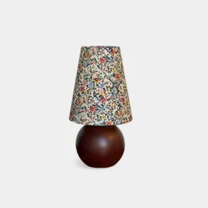 Floral table lamp with colorful botanical shade and dark wooden spherical base on white background