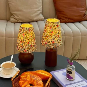 Pair of matching floral table lamps on coffee table in modern living room lounge setting