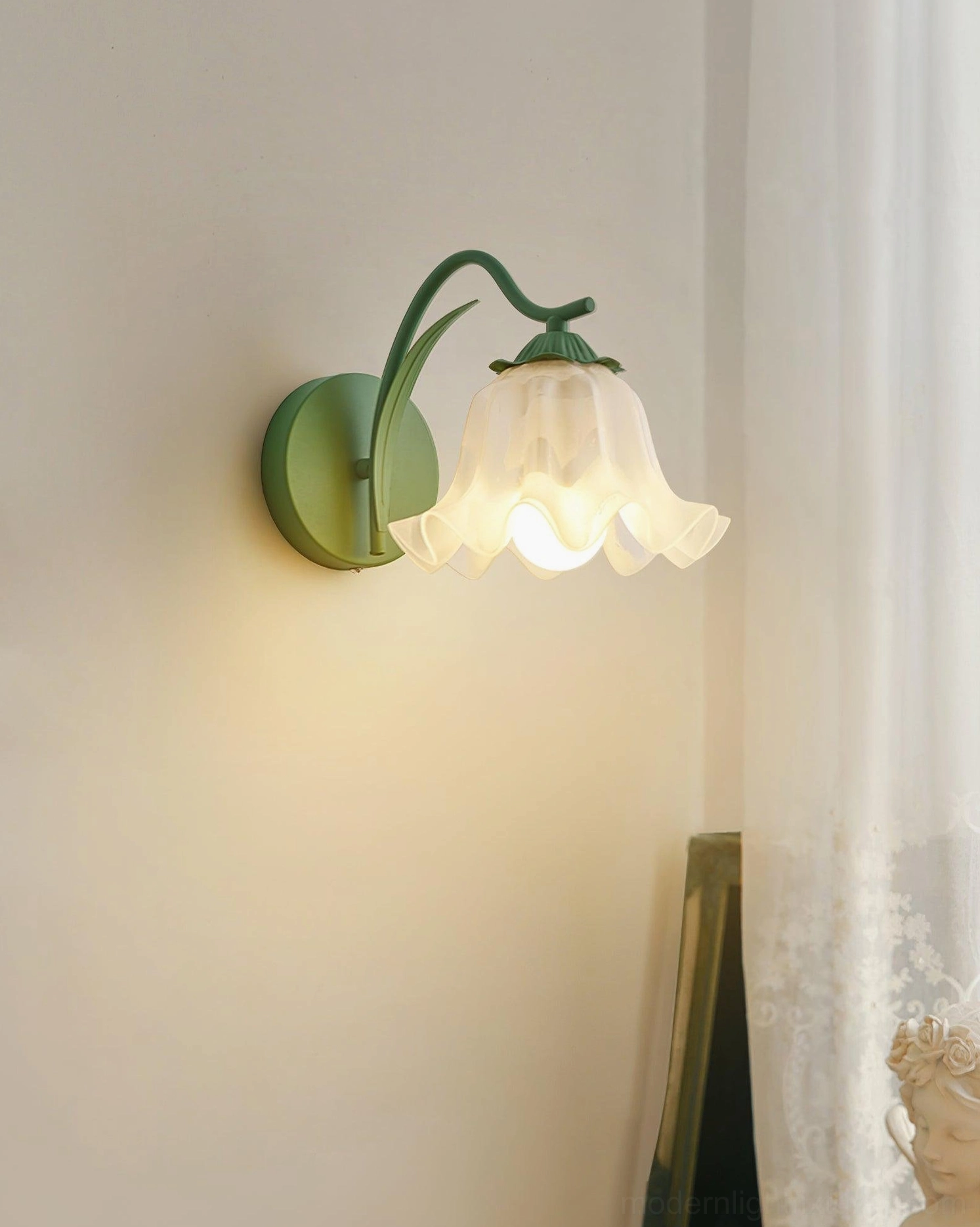 Single-bulb lily valley wall sconce with frosted glass shade and matte metal bracket