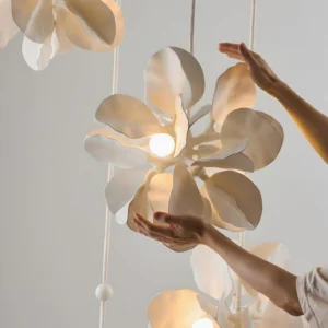 Close-up detail of carved petal texture on warm white matte flower shade with LED globe bulb