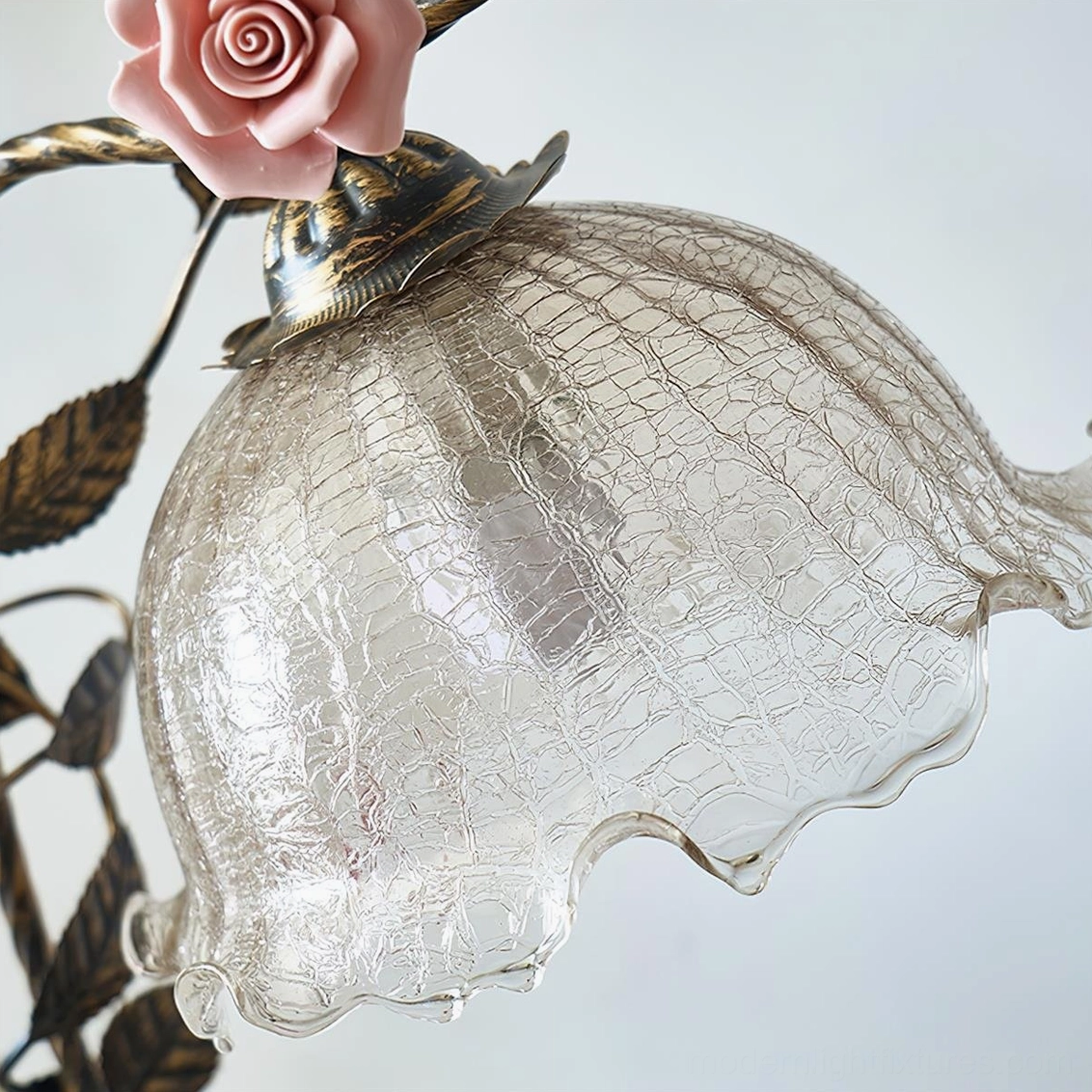 Florielle rose lamp paired with vintage décor elements, books, and botanical styling on side table