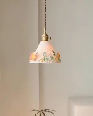 Florynna ceramic pendant lamp hanging in minimalist interior corner with warm ambient lighting showing off-white ribbed shade and brown twisted fabric cord
