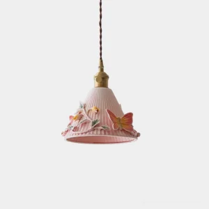 Florynna ceramic pendant light with pink ribbed shade featuring sculptural butterfly and floral relief details and brass hardware on white background