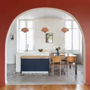 Multiple Flowerpot pendant lights in warm colors suspended above Nordic dining table creating layered illumination