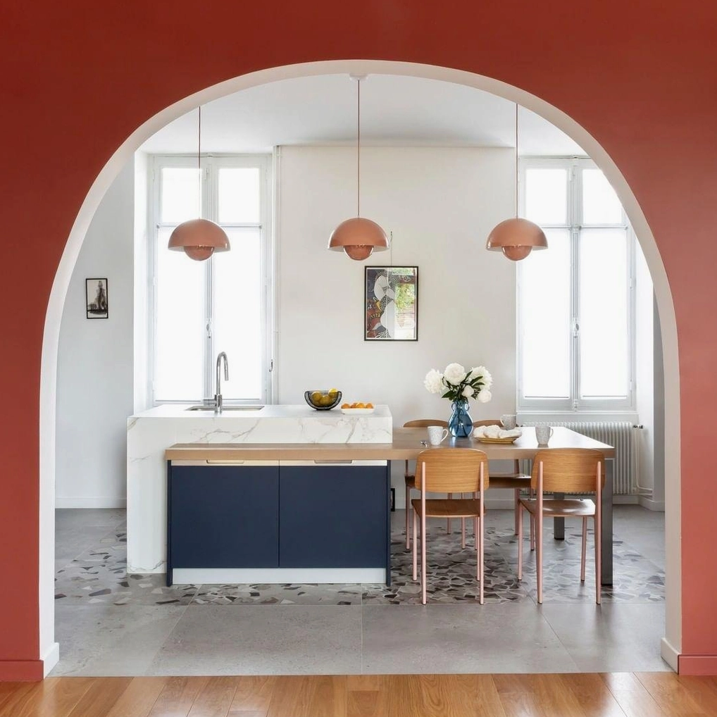 Multiple Flowerpot pendant lights in warm colors suspended above Nordic dining table creating layered illumination