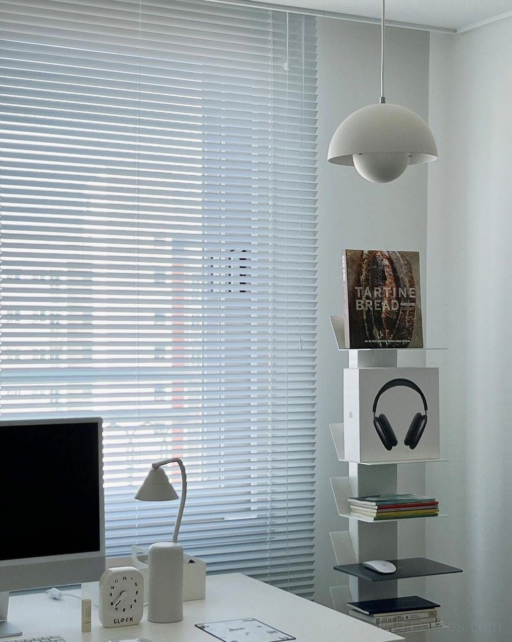 Three Flowerpot pendant lights aligned above dining table creating intentional linear composition