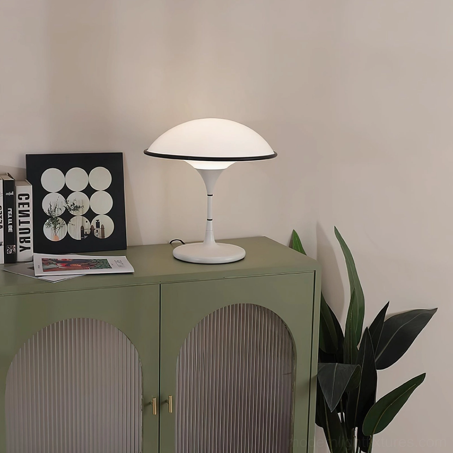 Fontana modern table lamp side view on green cabinet with warm glowing light