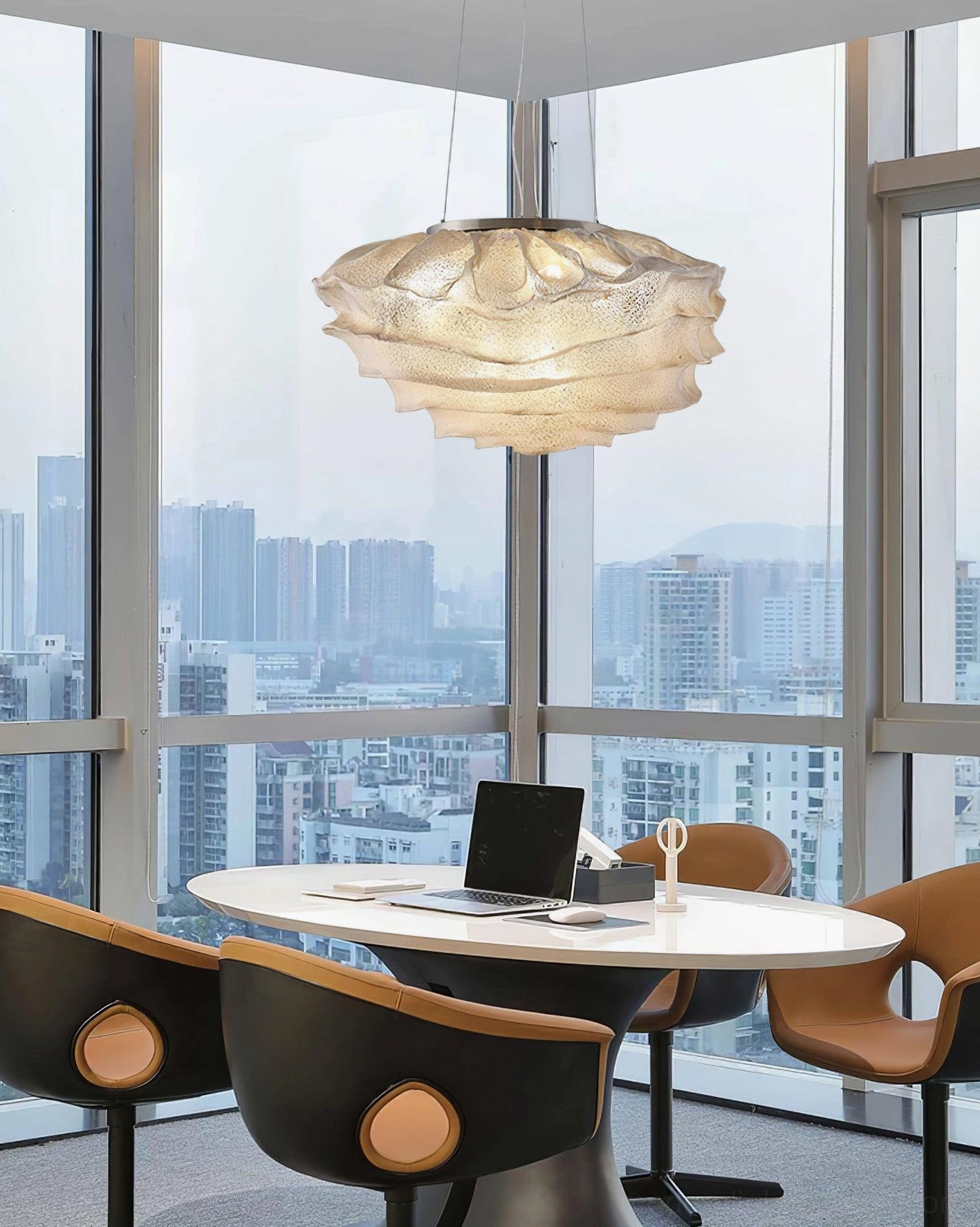 Large Forsyth ruffled pendant lamp installed above round dining table in modern high-rise urban lounge setting