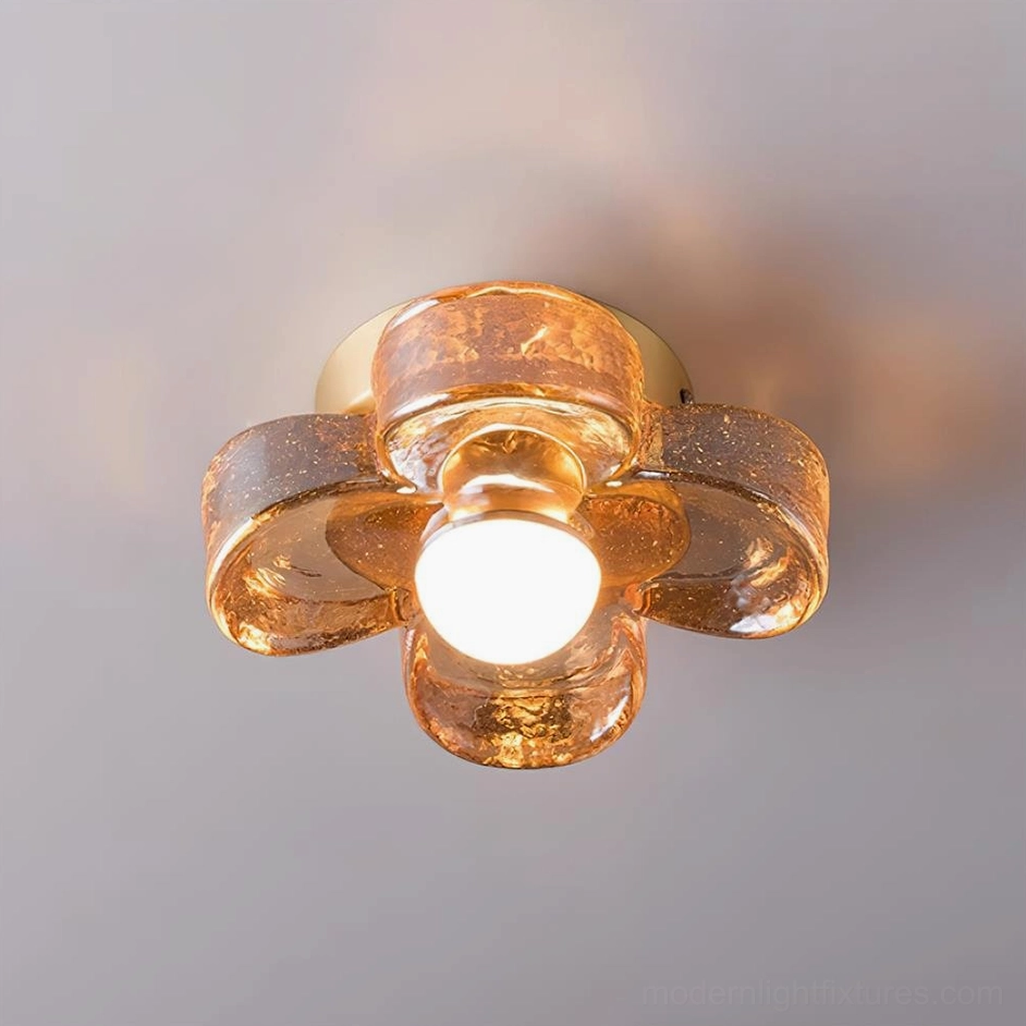 Topdown view of hand-blown amber glass four-leaf clover lighting fixture showing textured bubble glass detail and warm white LED