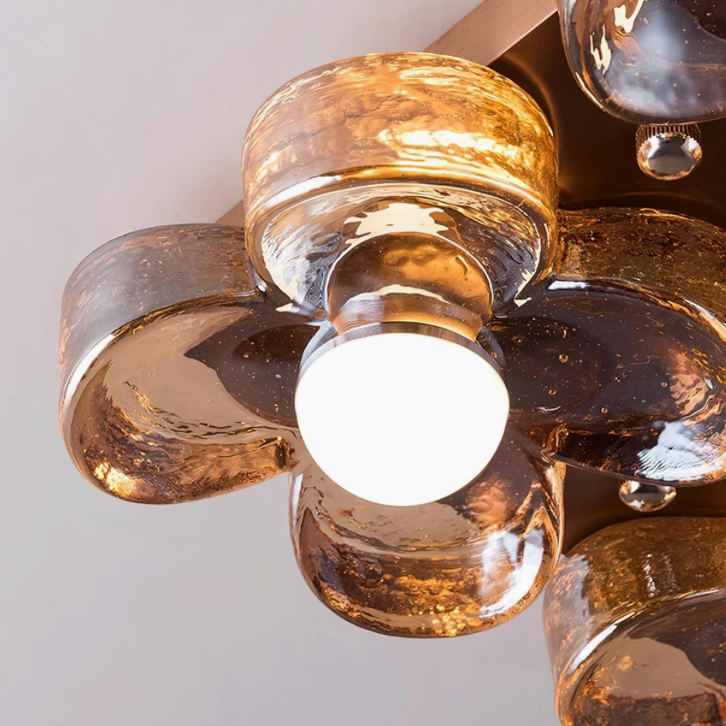 Illuminated four-leaf clover flush mount light showcasing warm amber glow and artistic bubble glass texture