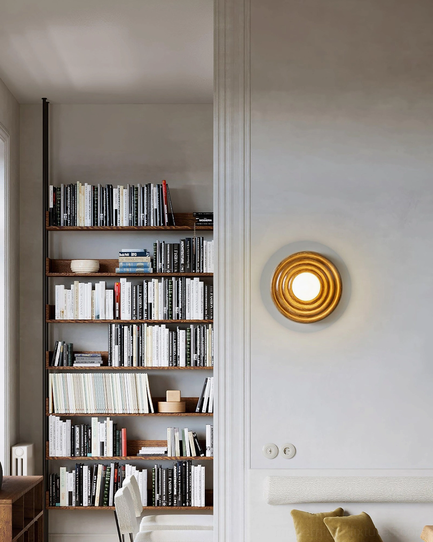 Francie modern wall sconce light in minimalist library living room with built-in bookshelves and warm ambient glow