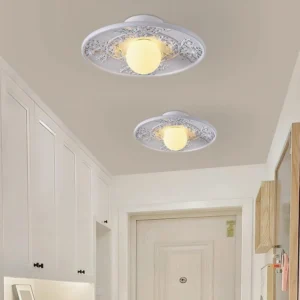 Dual vintage French ceiling light fixtures with ornate white resin floral trim installed in residential hallway entryway