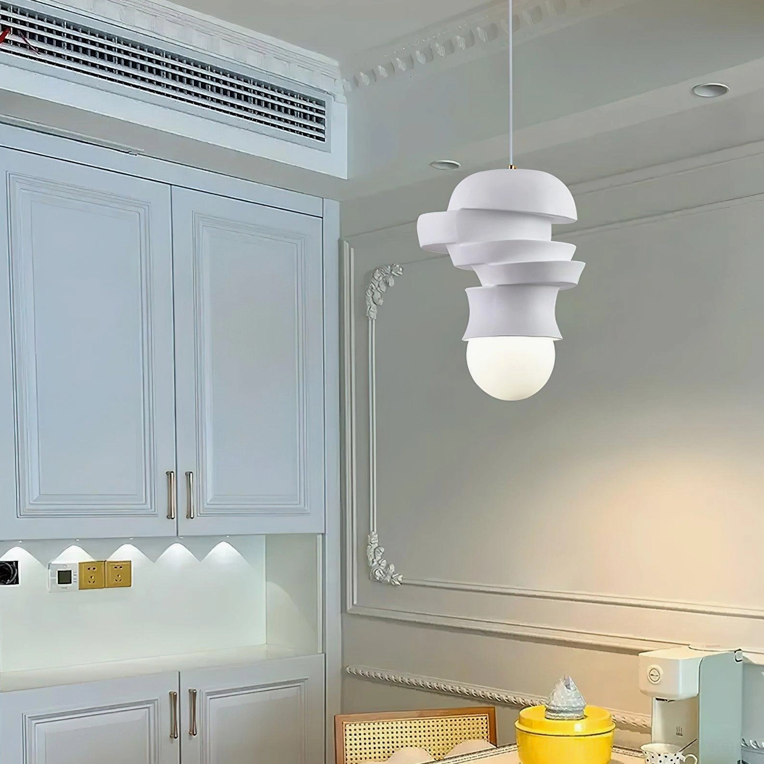 Layered disc pendant lamp installed in French style kitchen dining space, creamy minimalist interior decor eye-level perspective