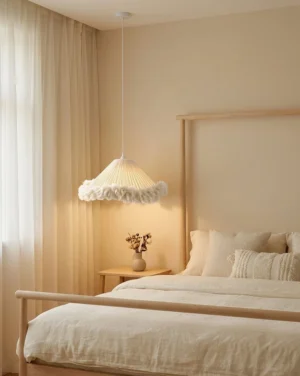 Boho coolie pendant light installed in warm master bedroom above upholstered seating area, creating soft ambient glow complementing rustic neutral bedding and natural wood furniture
