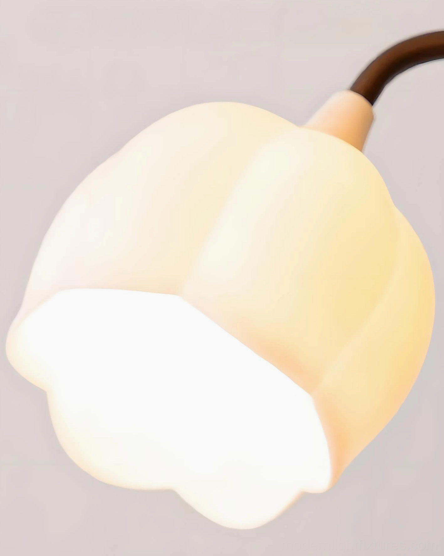Close-up macro view of single milky frosted glass bud shade with warm glowing light