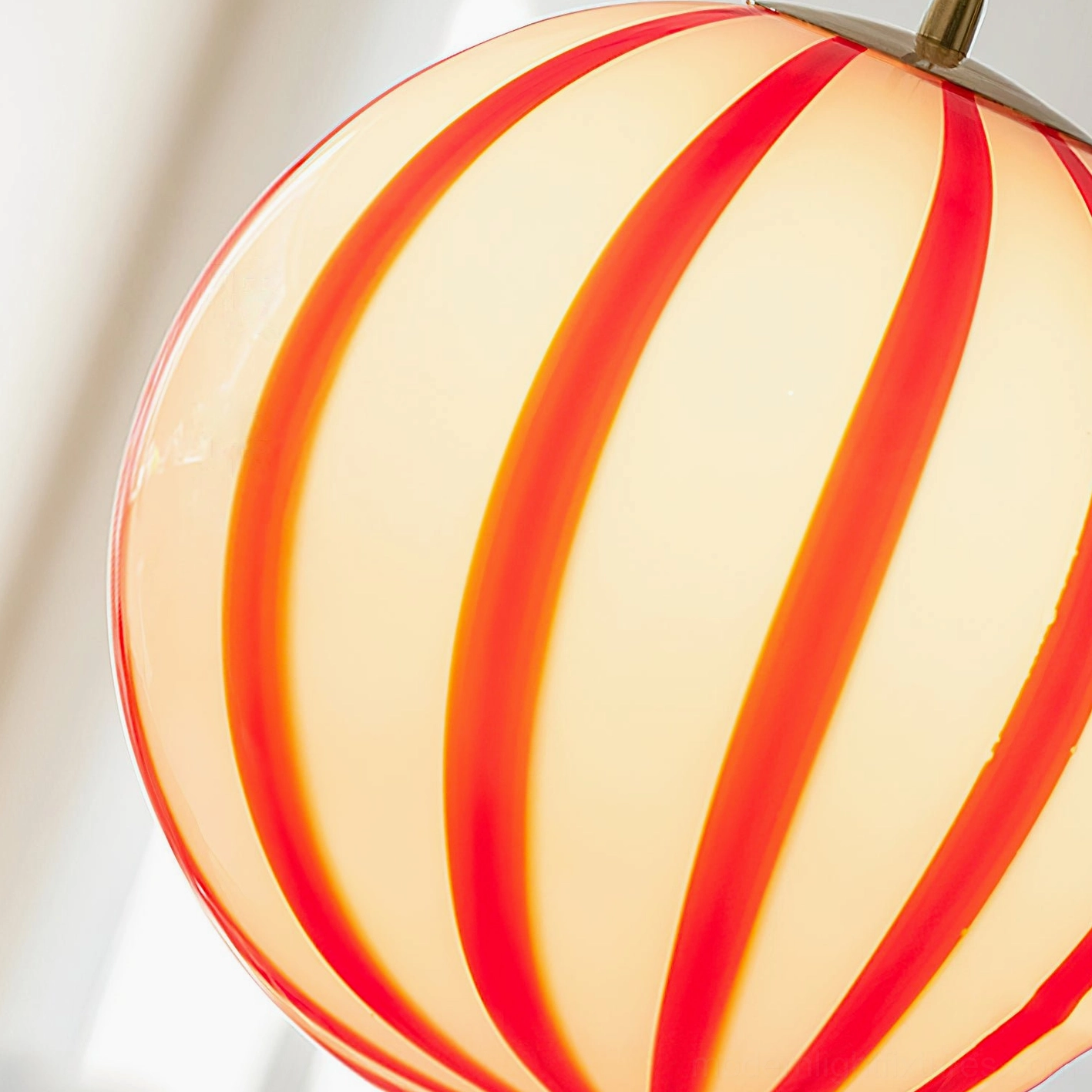 Red striped pendant light with frosted glass shade creating soft directional lighting