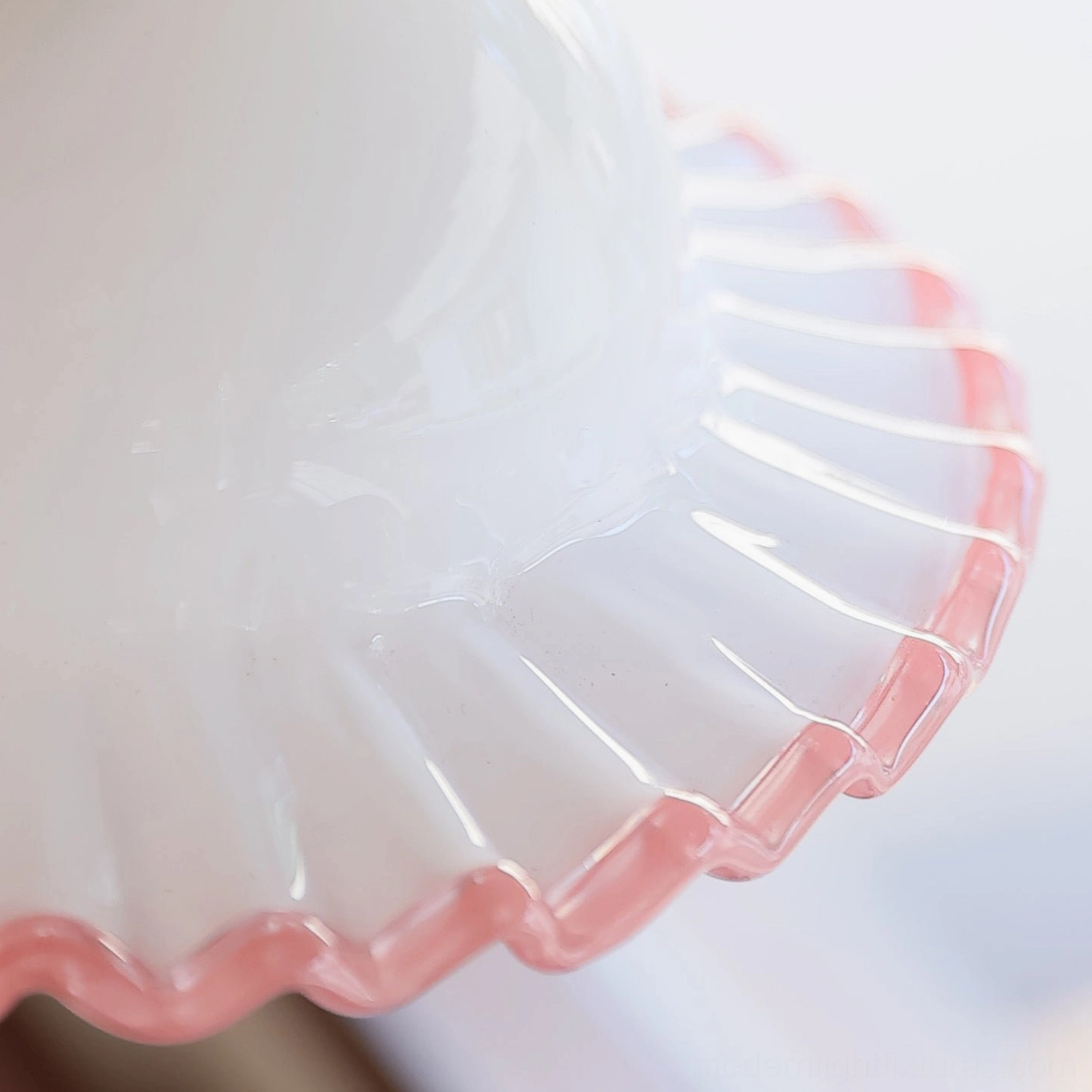 Close-up macro shot of frosted milk glass dome with hand-applied blush pink scalloped ruffled edge detail