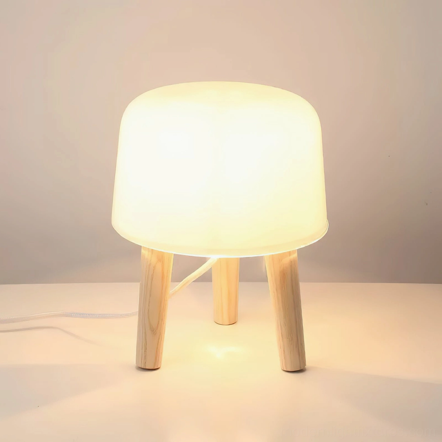 Close-up front view of illuminated milk glass table lamp showing frosted glass diffuser and warm glowing light effect
