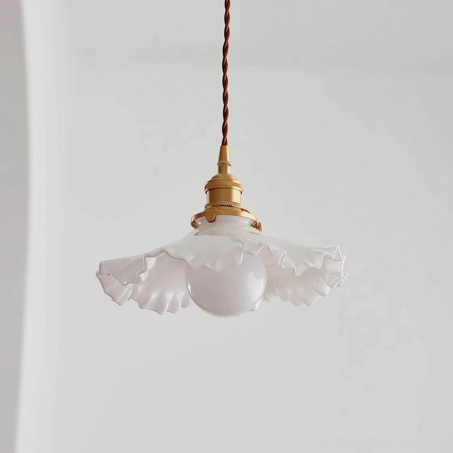 Frosted ruffled glass pendant light unlit in studio setting, showing white textured shade with brass base and fixture