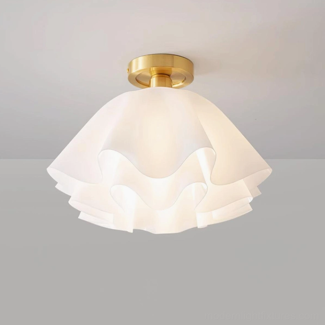 Close-up top-front view of Gailon pleated ceiling fixture showing layered frosted acrylic shade and brass base detail