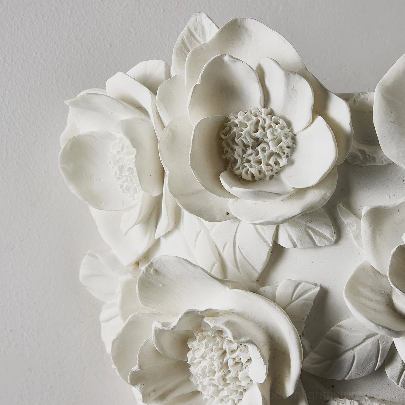 White ceramic floral wall lamp artistic side perspective, sculptural botanical design