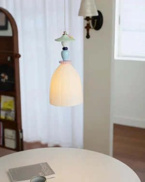 Modern ceramic dome pendant lamp hanging above wooden dining table with warm ambient lighting