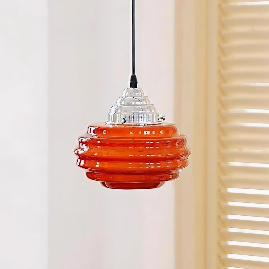 Bright orange vibrant gelato ribbed glass pendant lamp front low-angle close-up with black suspension cord in interior setting