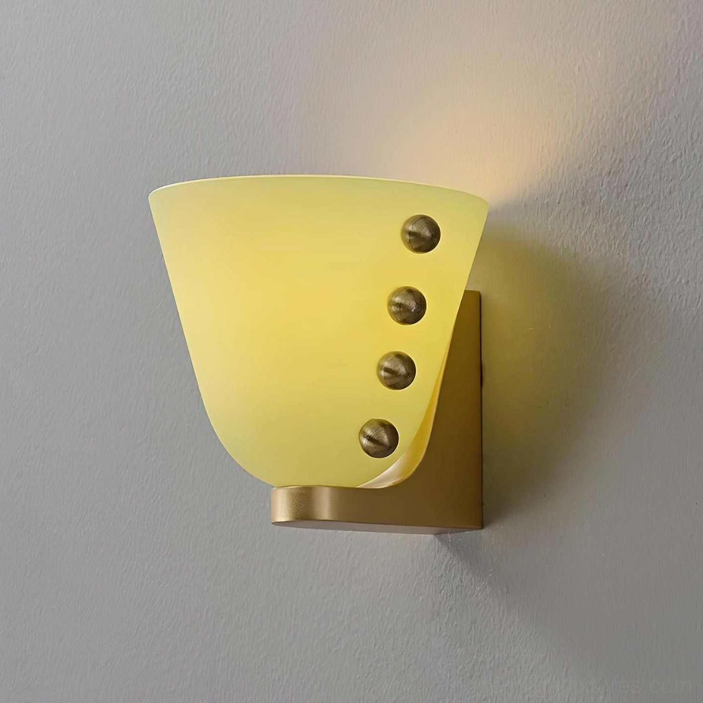 Gemma wall sconce illuminated showing warm ambient glow and asymmetric glass layer construction