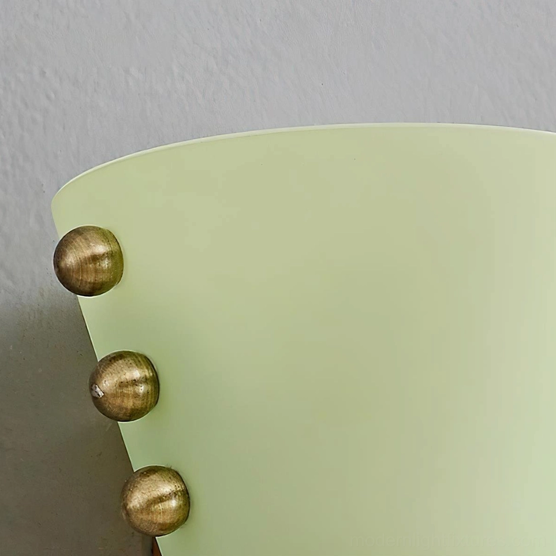 Gemma pink frosted glass wall sconce showing jewelry-inspired spherical brass stud details