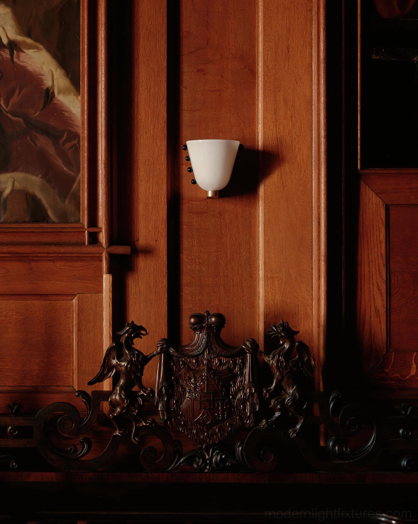 Gemma modern wall sconce in white with black decorative dots, installed on dark wood panel interior