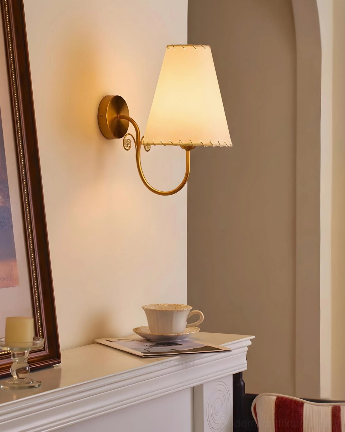 Gentle Bend wall sconce lit above fireplace mantel residential interior warm beige shade ambiance