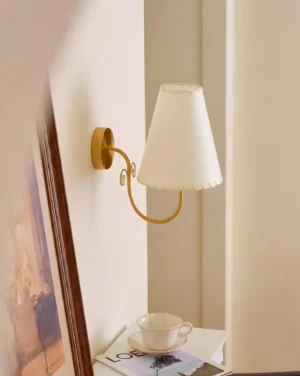 Gentle Bend wall sconce in hallway interior design setting with framed artwork and decorative accessories