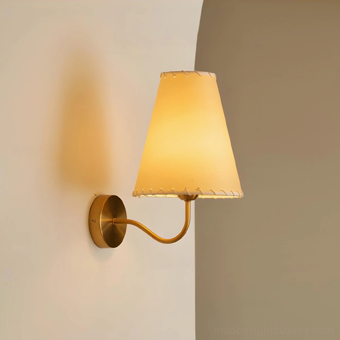 Gentle Bend wall sconce side angle lit warm beige shade two-tone backdrop curved brass arm