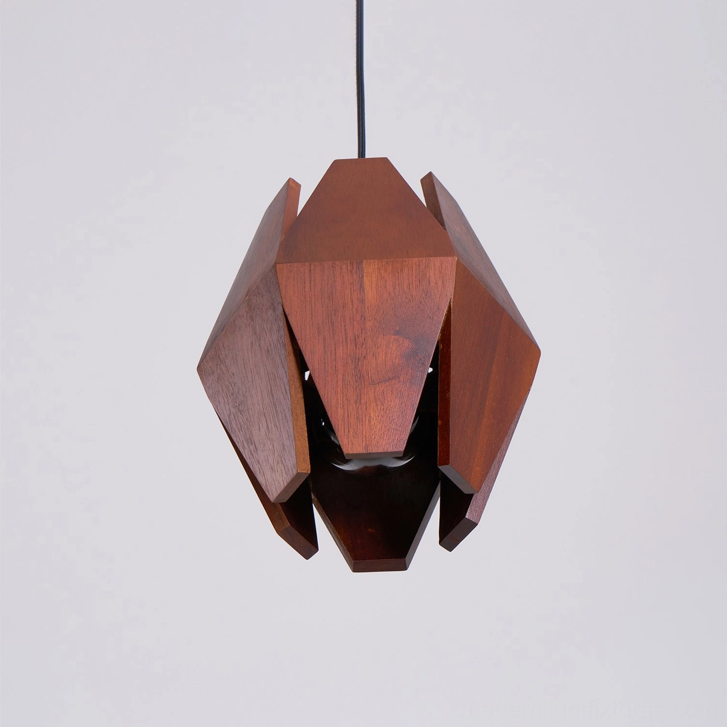 Geometric pendant lamp showcasing sculptural walnut shade design and construction quality