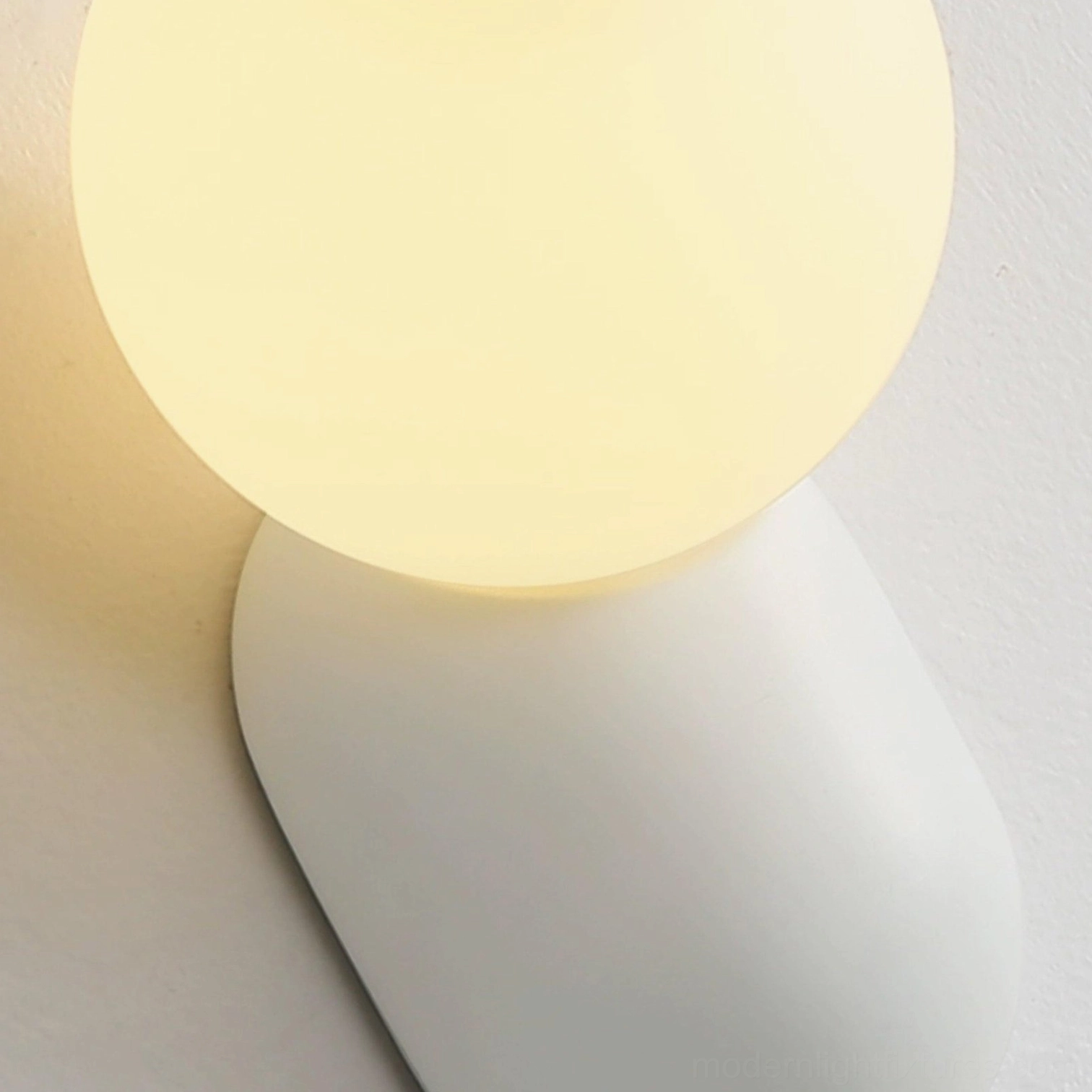 Geometric cantilever wall sconce creating sculptural shadow patterns on wall surface, artistic lighting