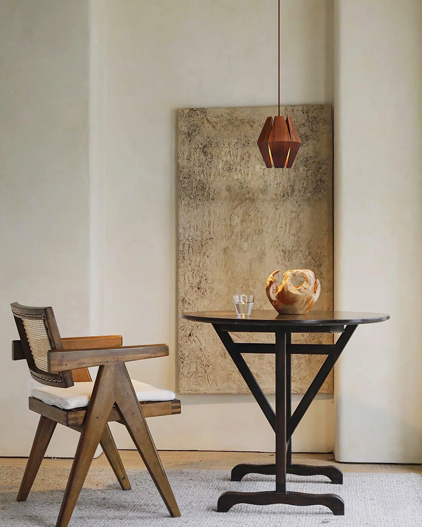 Modern pendant light suspended above dining table in minimalist Japandi style interior
