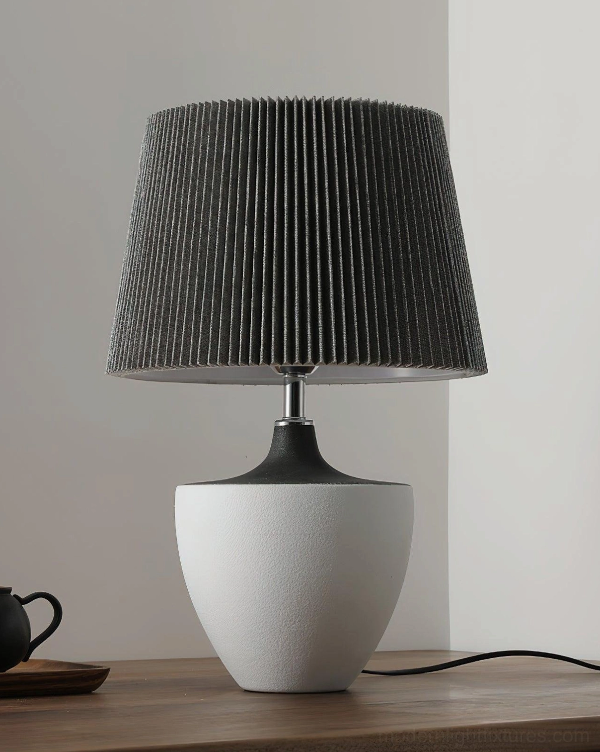 Modern Ghassan ceramic table lamp with black pleated shade and urn-shaped white base with metal stem