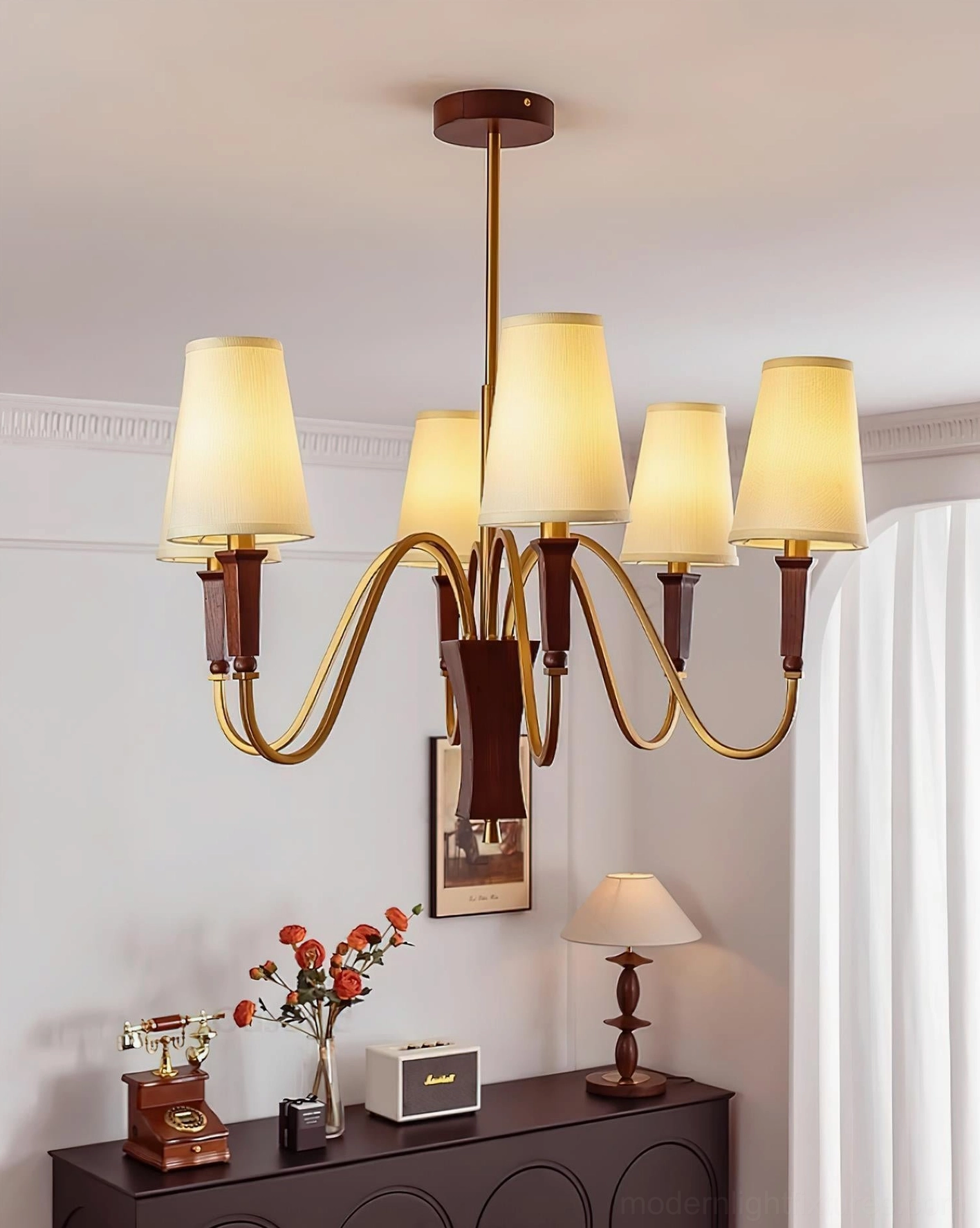 Gianna chandelier three-quarter angle view displaying sculpted brass arms and warm metallic finish detail