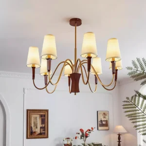 Multi-head Gianna chandelier installed in vintage European living room with warm brass finish and off-white fabric shades