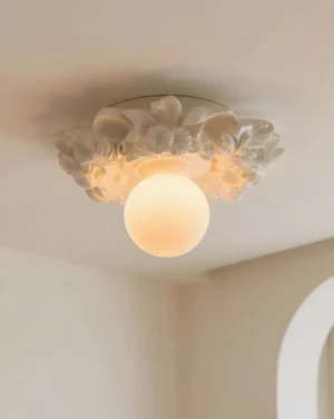 Beige ivory resin floral flush mount ceiling light overhead close-up, embossed leaf flower design with warm glowing bulb, neoclassical botanical style