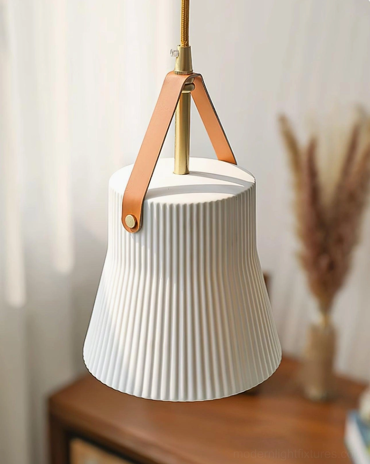Contemporary ceramic pendant light fixture showing leather suspension strap and minimalist design aesthetic