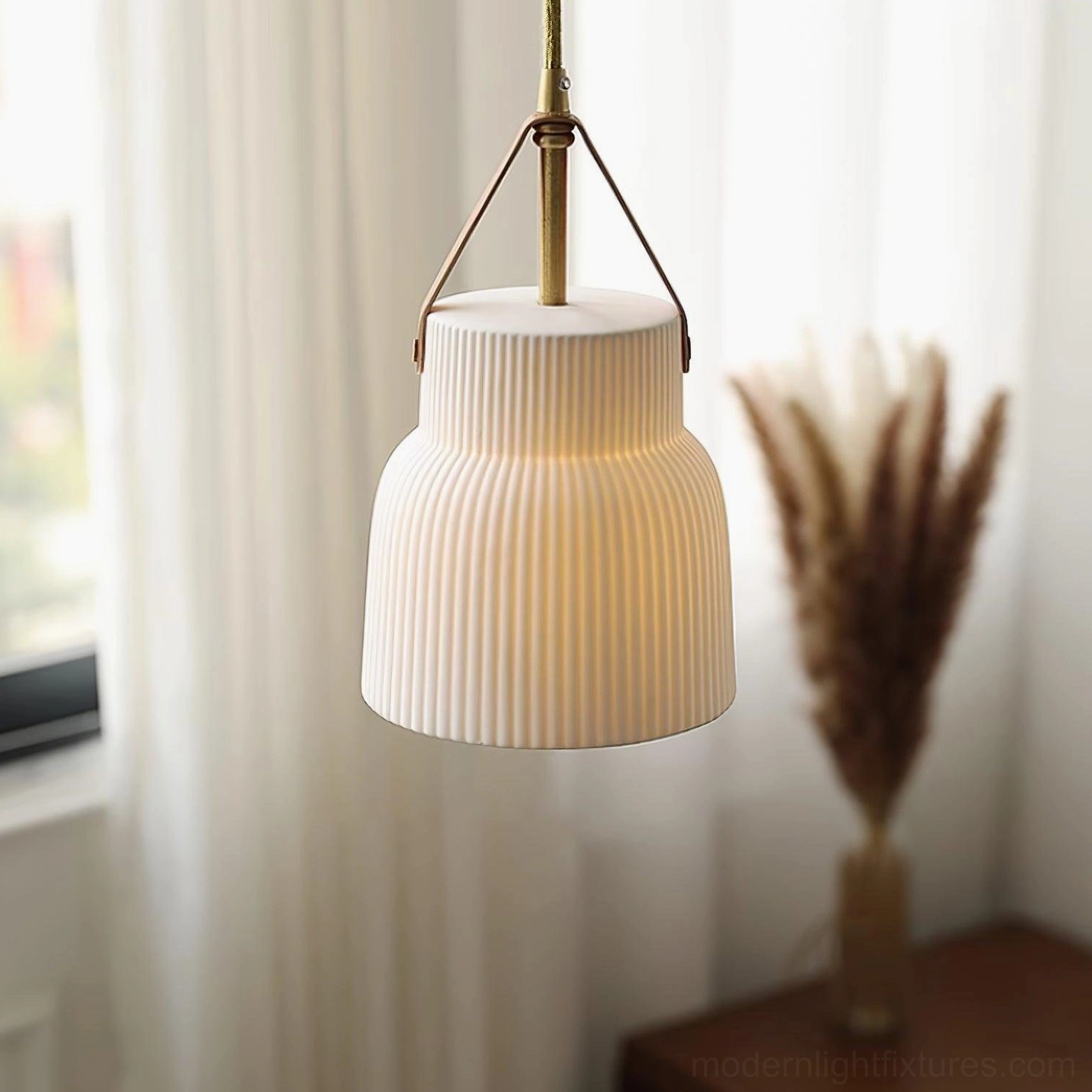 Tiered ceramic ridged pendant light three-quarter angle with warm ambient interior lighting above windowsill pampas grass decor