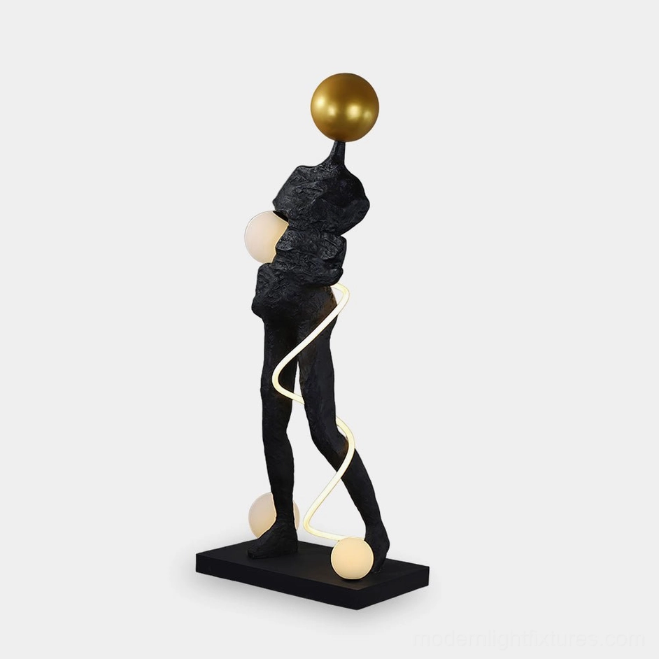 Ginasta abstract sculpture floor lamp with textured black resin body and gold frosted glass accents, front left view studio shot