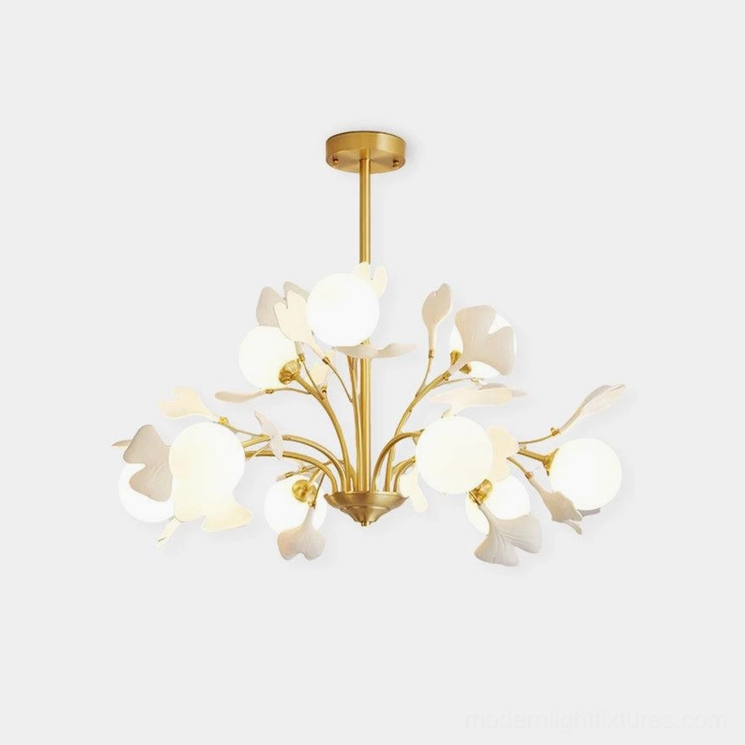 Ginkgo ceramic chandelier with hand-formed leaves, overhead studio view showing brass frame and frosted glass shades