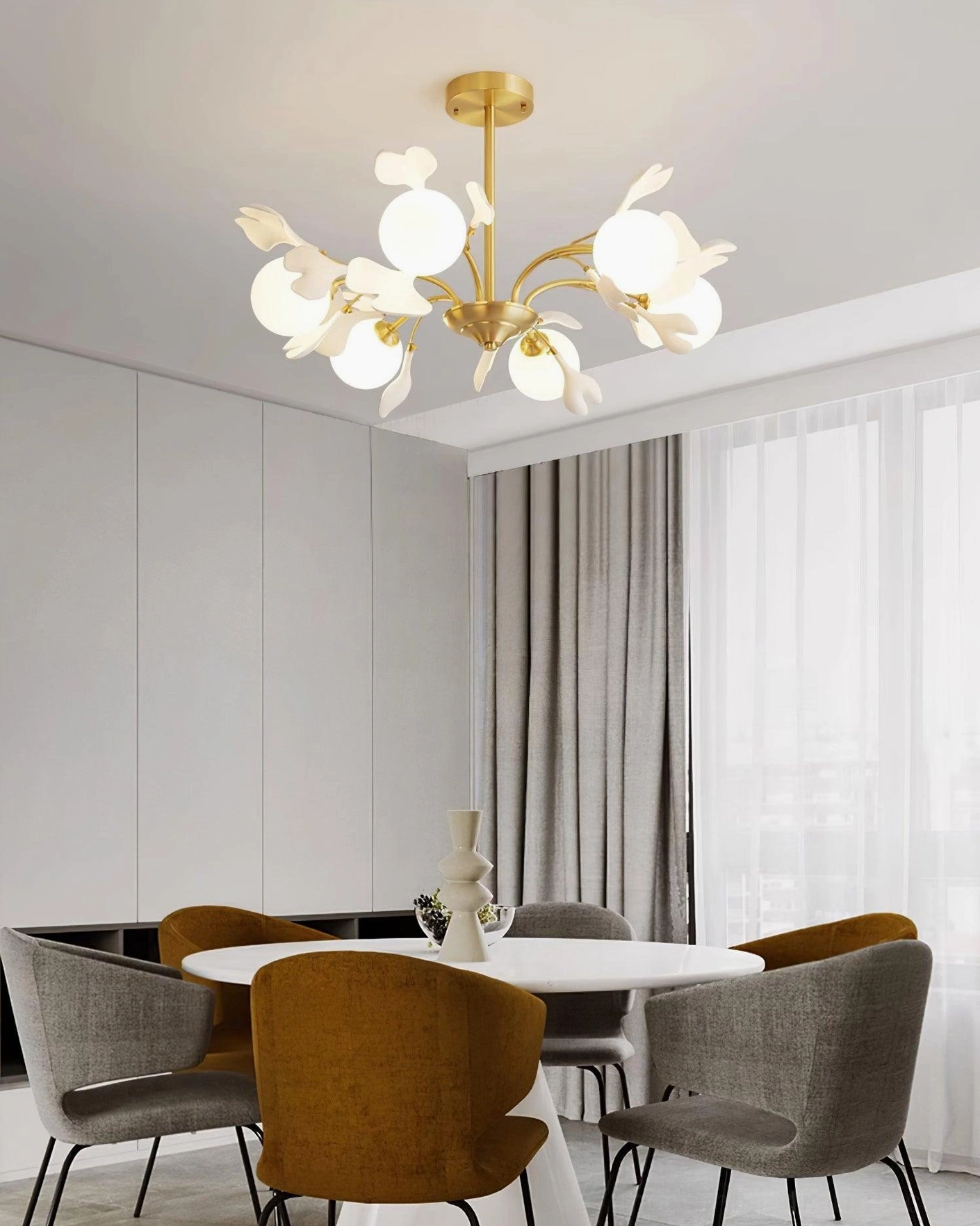 Compact ginkgo ceramic chandelier above modern dining table, eye-level view with warm ambient lighting